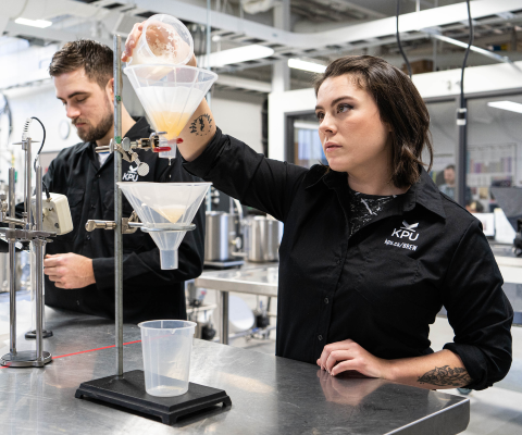 Students pouring beer into funnels in lab