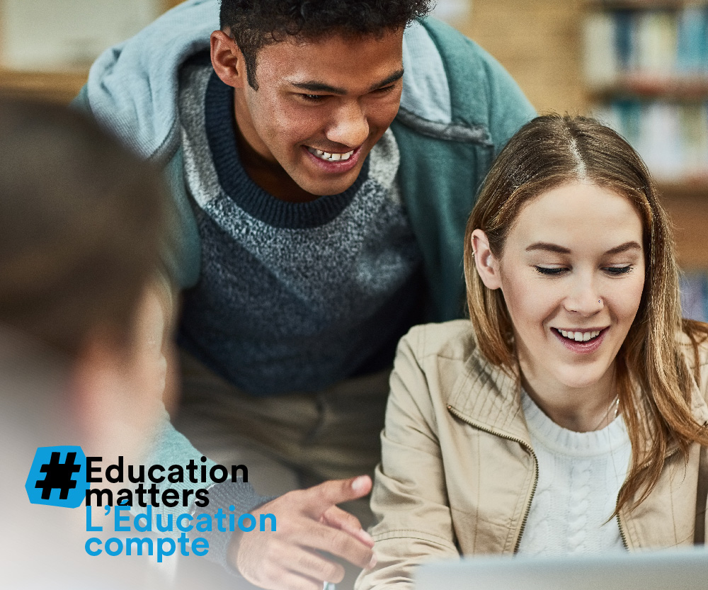 Happy young students in front of a laptop